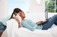 Mother and daughter lounging with laptop