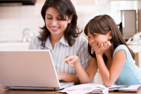 Mother and daughter smiling at laptop