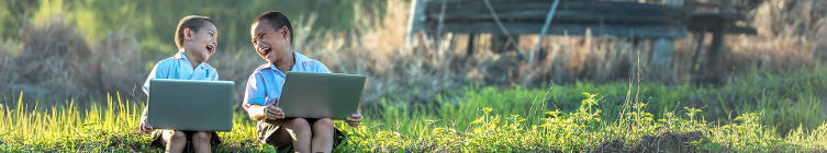 Two boys with laptops, laughing