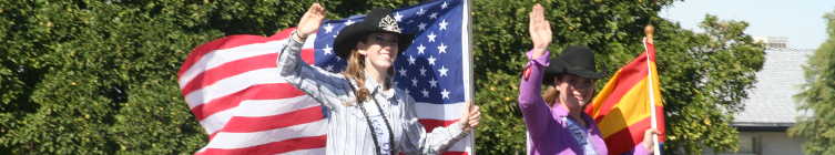 Cowgirls at Billy Moore Days parade with national and state flags